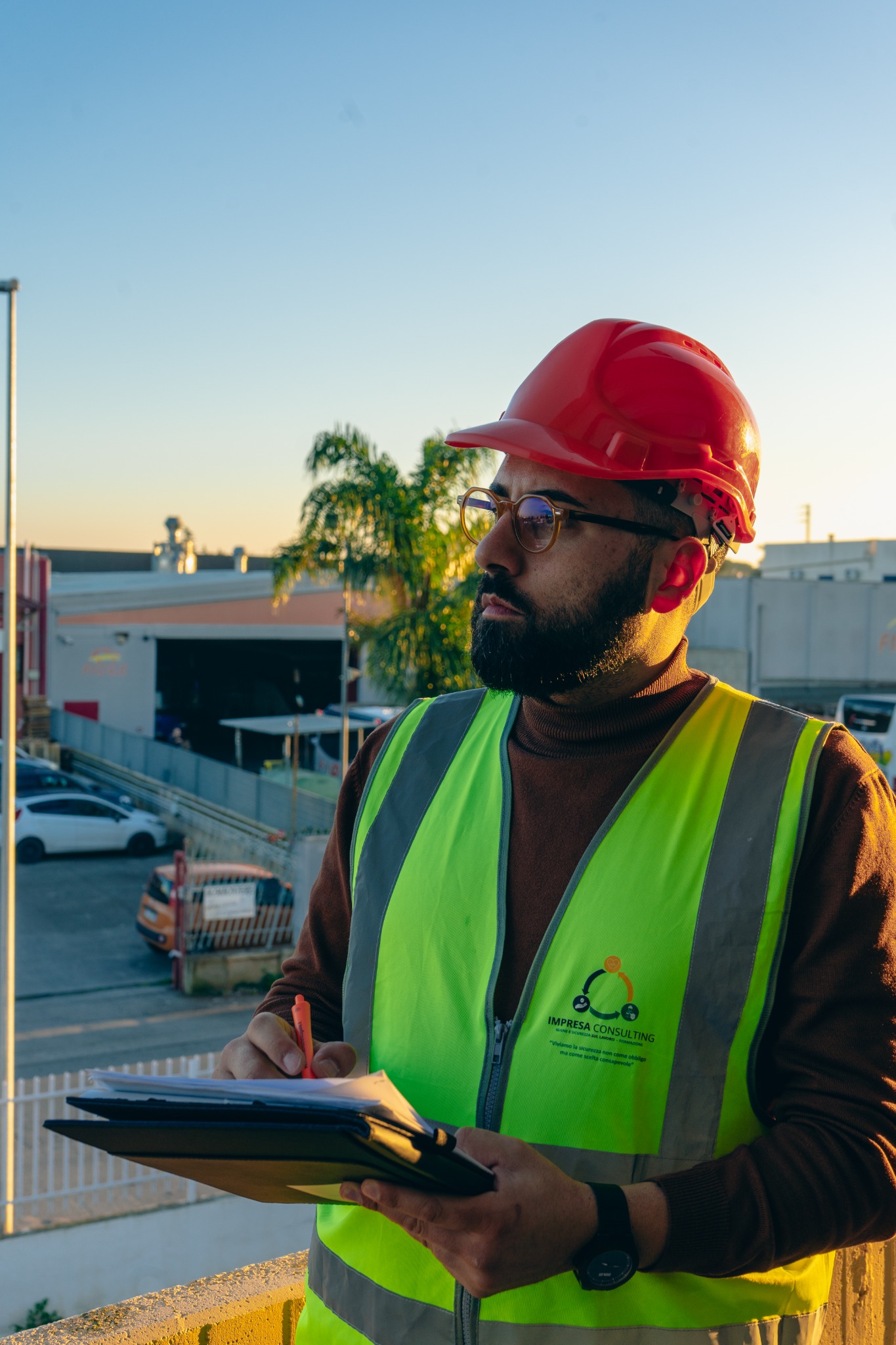 Professionista Impresa Consulting durante un sopralluogo, con casco e gilet di sicurezza