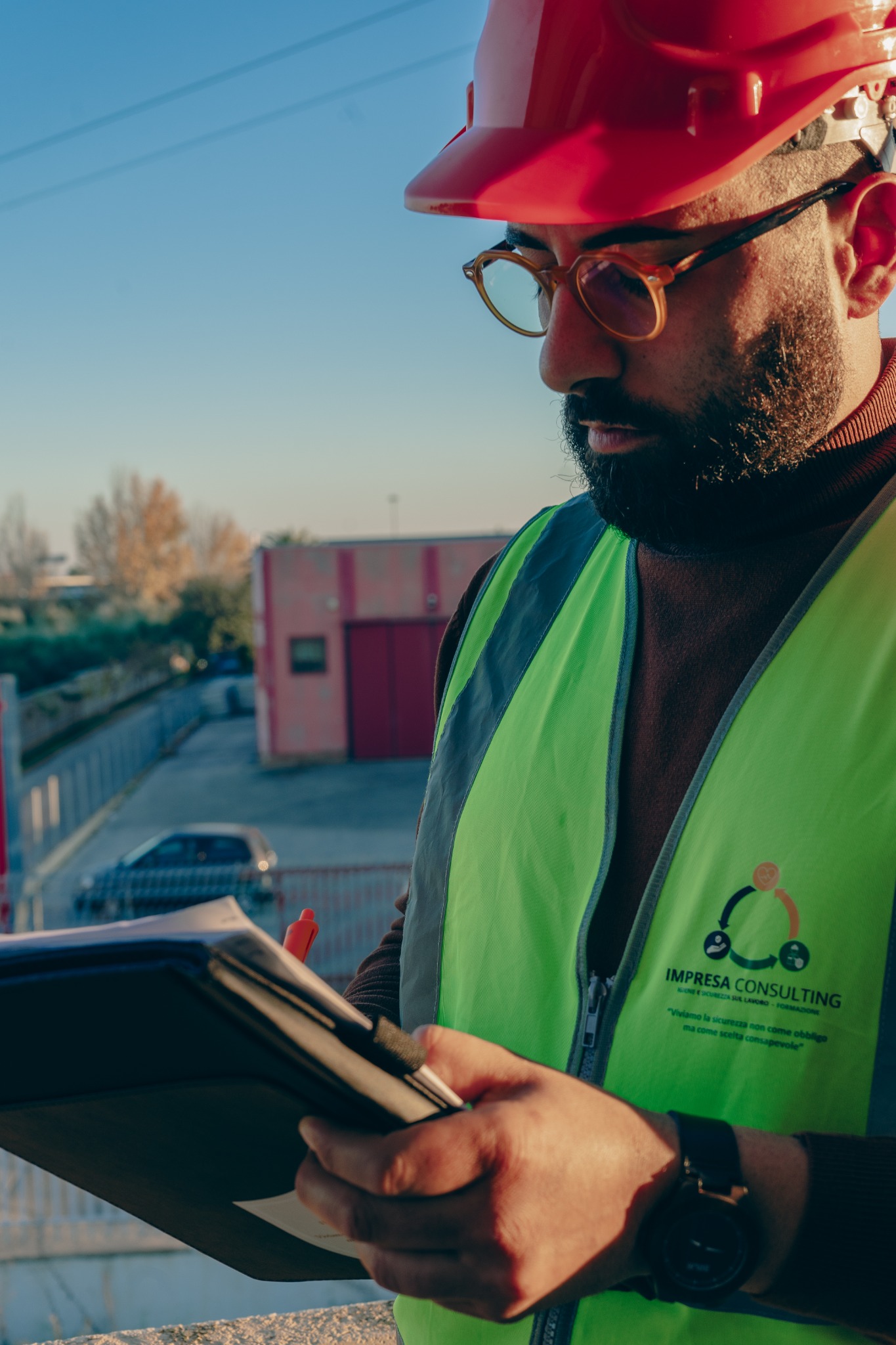 Professionista Impresa Consulting durante un sopralluogo, con casco e gilet di sicurezza